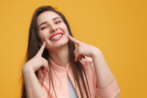 Femme pointant vers son sourire après avoir obtenu des placages