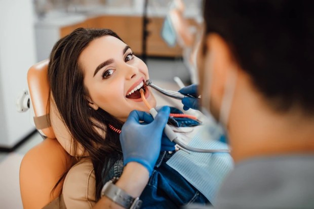 jeune femme patiente visitant un bureau de dentiste pour le nettoyage des dents