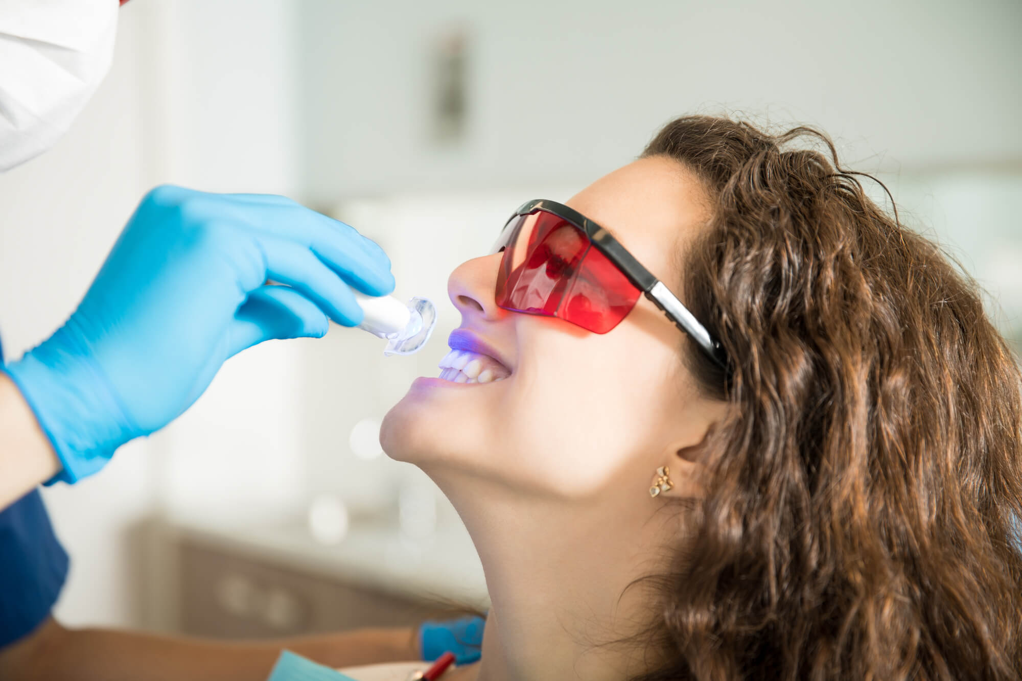 Femme se blanchissant les dents après le nettoyage des dents à Cary NC