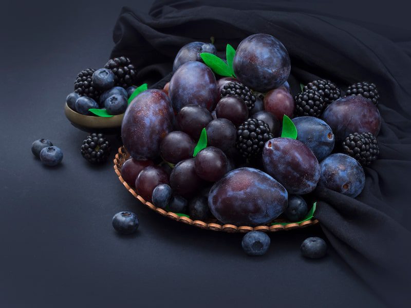 Baies et autres fruits noirs dans un bol.